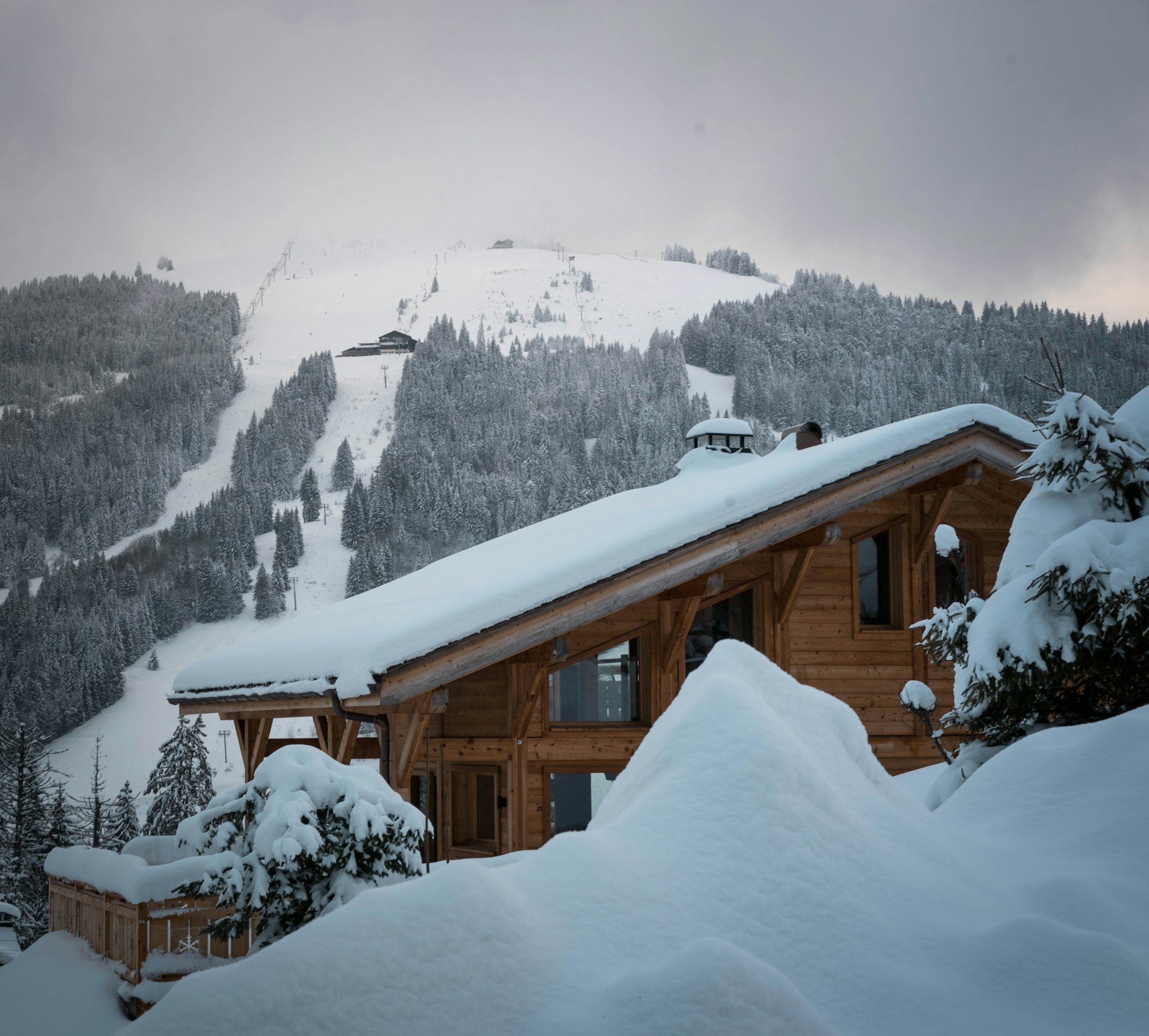 Chalet sous la neige face aux pistes de ski, Alpes